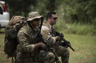 A U.S. Army Green Beret from 1st Battalion, 1st Special Forces Group (Airborne), and Air Force Staff Sgt. Mike Triana, independent duty medical technician paramedic from the 67th Fighter Squadron, establish a security perimeter during a small unit tactics exercise Aug. 21, 2019, at the Jungle Warfare Training Center, Camp Gonsalves, Japan. The Green Berets hosted the jungle training with Triana and other Team Kadena Airmen, assigned to the 18th Wing, as part of the Green Berets’ continuous combat readiness program. They specialize in the full spectrum of special operations throughout the Indo-Pacific Theater. (U.S. Air Force photo by Staff Sgt. Peter Reft)